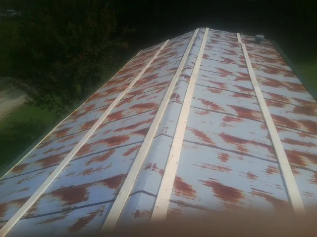 Rusted metal roof panels with new wood purlins before replacement — Storm Damage Roof Repair in Eutaw by Roofing Brothers