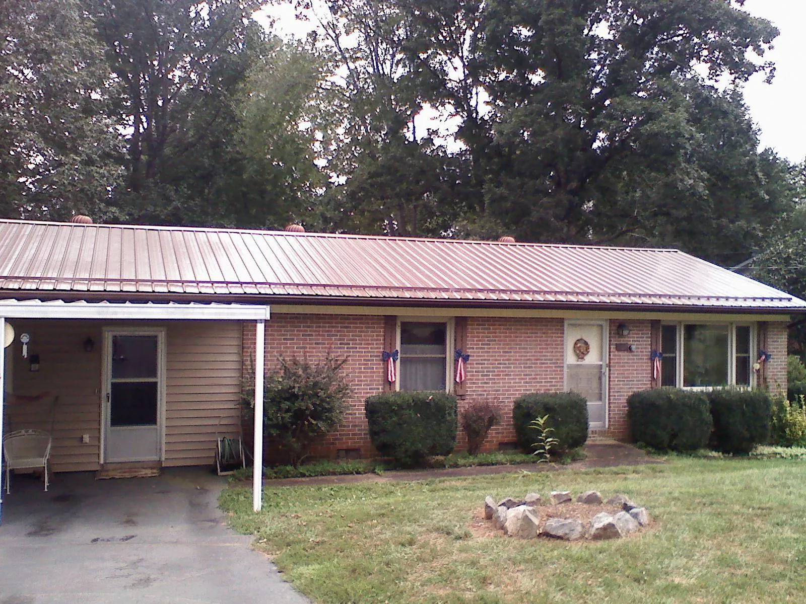 Bronze metal roof and carport on a brick ranch home — Roof Repair work by our crew in Eutaw